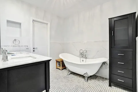 a spacious bathroom with a bathtub a sink and a mirror