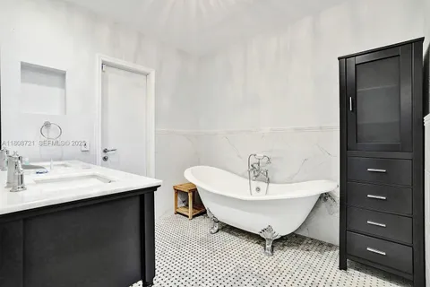 a spacious bathroom with a bathtub a sink and a mirror