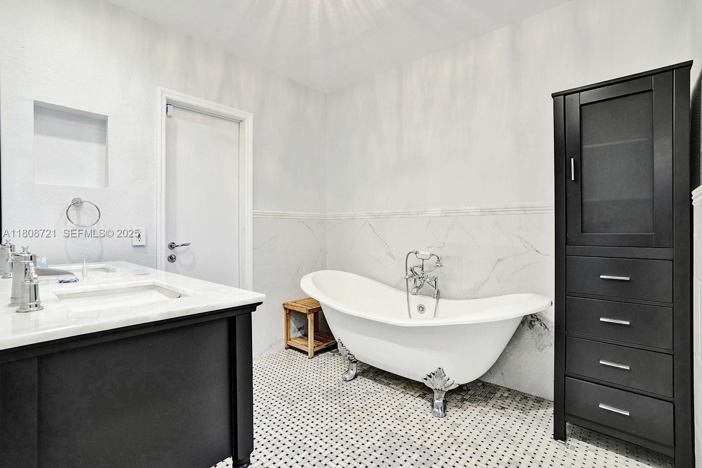 1245 Wiley Street Hollywood, FL 33019 - Photo 32 of 43 a spacious bathroom with a bathtub a sink and a mirror