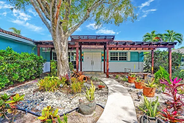 a front view of a house with a yard and a garden