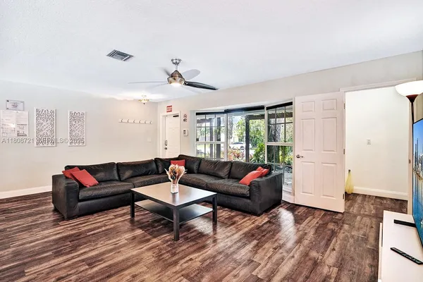 a living room with furniture and a wooden floor