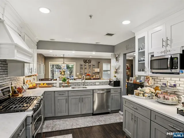 a kitchen with a refrigerator stainless steel appliances a sink and cabinets