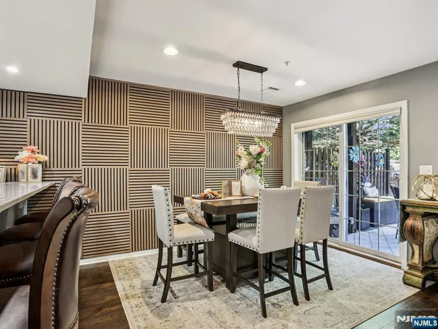 a kitchen with stainless steel appliances granite countertop a stove a kitchen island a dining table and chairs with wooden floor