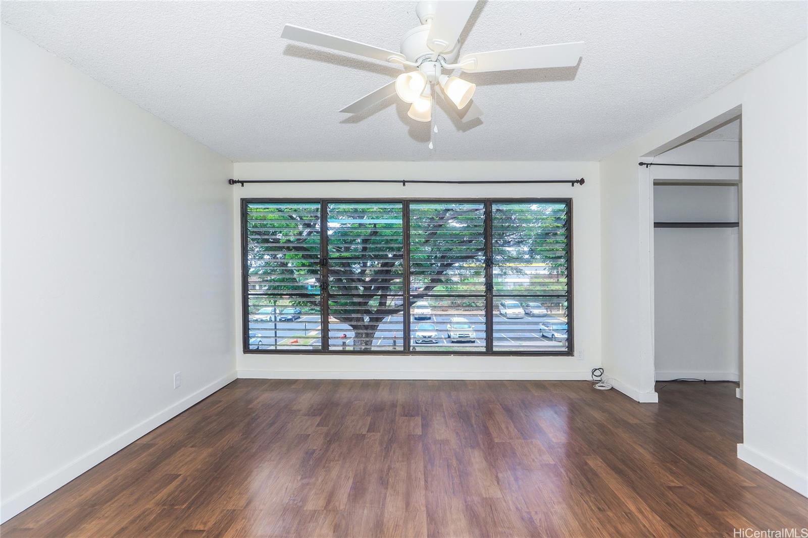 87-122 Helelua Street, Unit C204 Waianae, HI 96792 - Photo 2 of 19 an empty room with wooden floor fan and windows