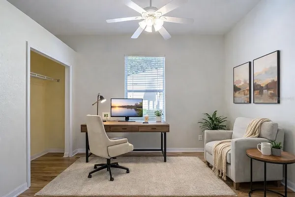 a view of a workspace with furniture and a window