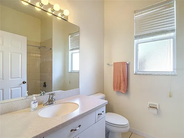 a bathroom with a granite countertop sink toilet a large mirror and shower