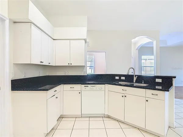 a kitchen with granite countertop a sink and cabinets