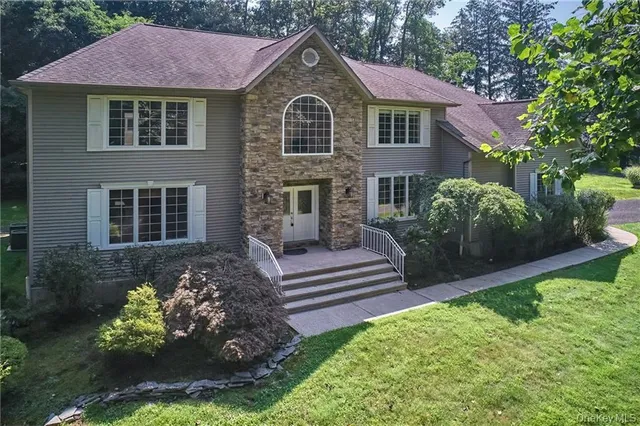 a front view of a house with a yard and a garden