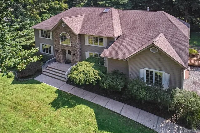 a aerial view of a house with a yard plants and large tree