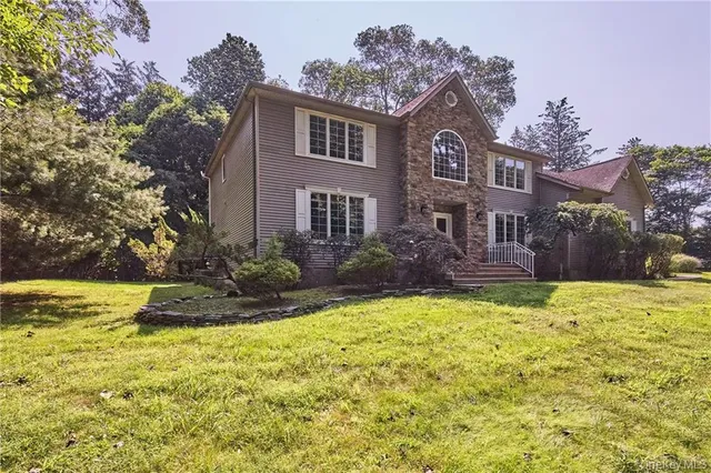 a house view with swimming pool and garden space