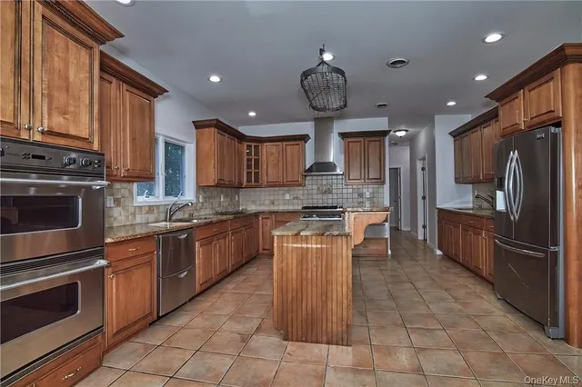 a kitchen with stainless steel appliances granite countertop a stove refrigerator sink and cabinets