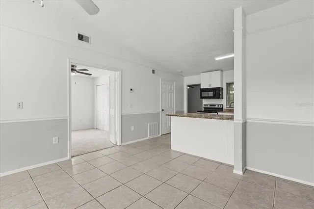 an empty room with windows and fan