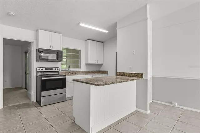 a kitchen with stainless steel appliances granite countertop a stove top oven a sink and dishwasher a refrigerator with wooden floor