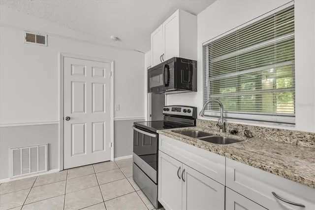 a bathroom with a granite countertop sink two mirror and a vanity