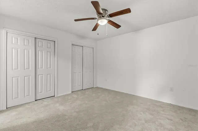 an empty room with fan and entrance