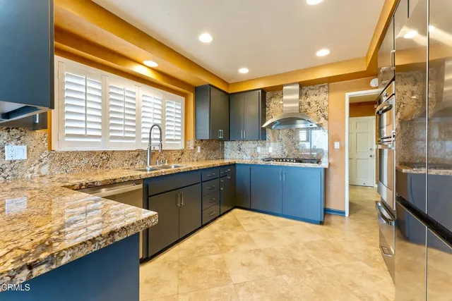 a kitchen with granite countertop sink and refrigerator