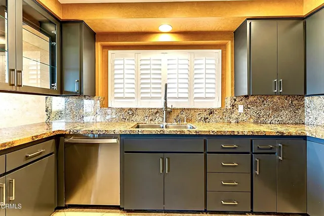 a kitchen with granite countertop a sink and a window
