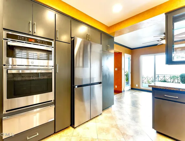 a kitchen with stainless steel appliances granite countertop a refrigerator a stove and a wooden floors