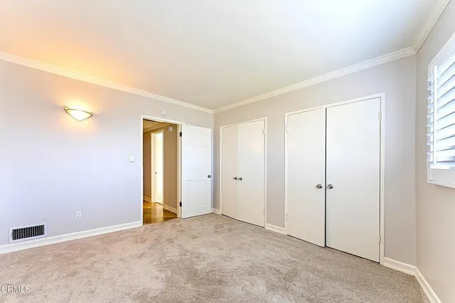 an empty room with windows and closet