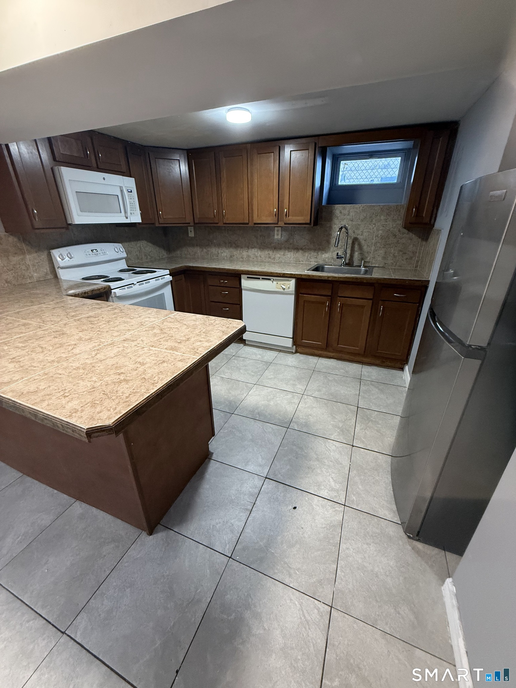 42 Cottage Street Bridgeport, CT 06605 - Photo 4 of 12 a kitchen with kitchen island granite countertop a stove a sink and a microwave