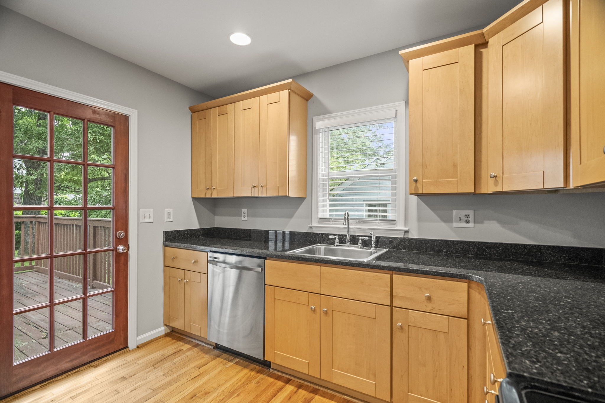 202 Cherokee Road Nashville, TN 37205 - Photo 8 of 35 a kitchen with granite countertop wooden cabinets a sink and a window