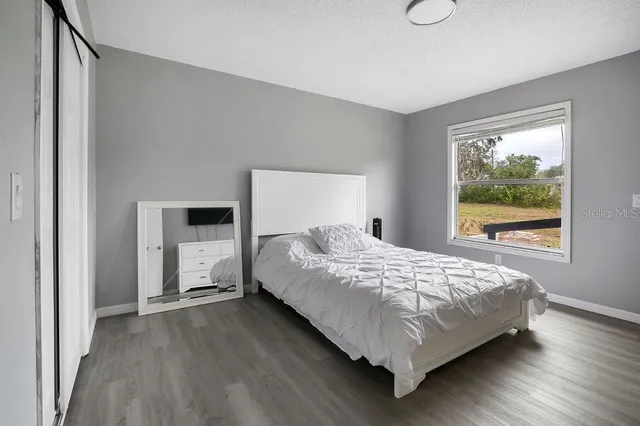 a bed sitting in a spacious bedroom next to a window