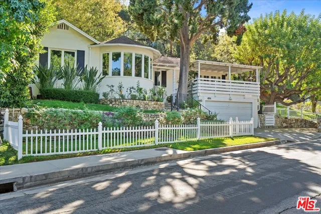 a front view of a house with a yard and potted plants