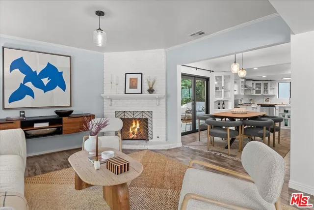 a living room with furniture a table and kitchen view