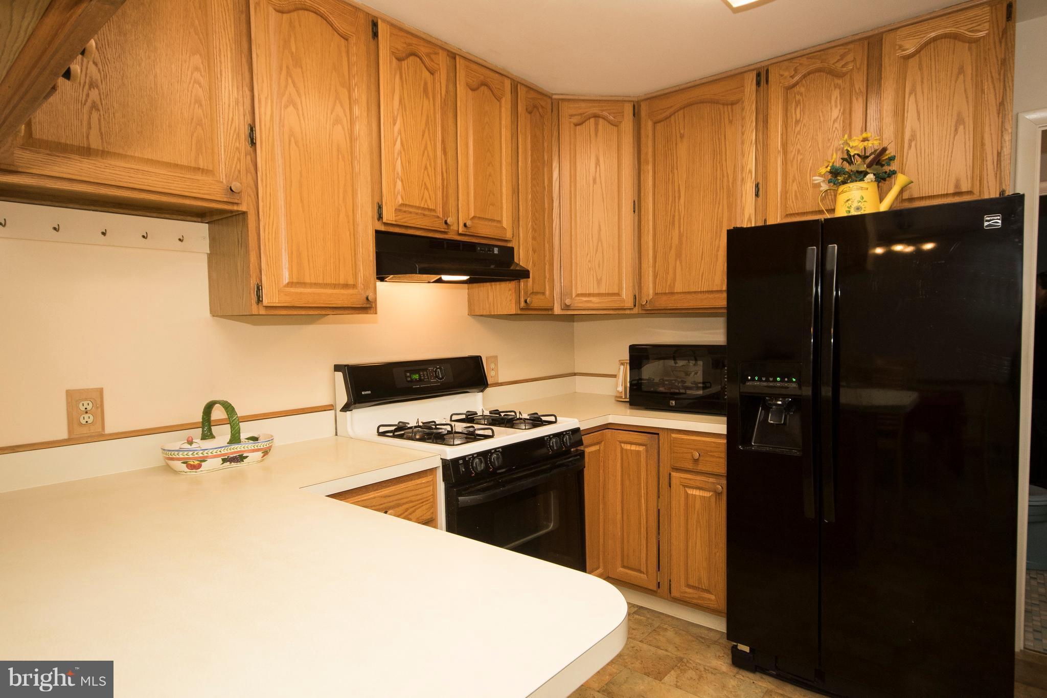 228 Embleton Road Owings Mills, MD 21117 - Photo 7 of 24 a kitchen with a sink a stove and refrigerator