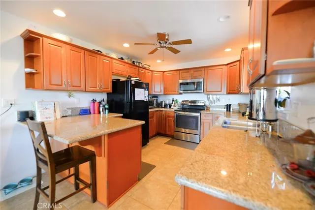 a kitchen with stainless steel appliances granite countertop a sink dishwasher stove and refrigerator with wooden floor