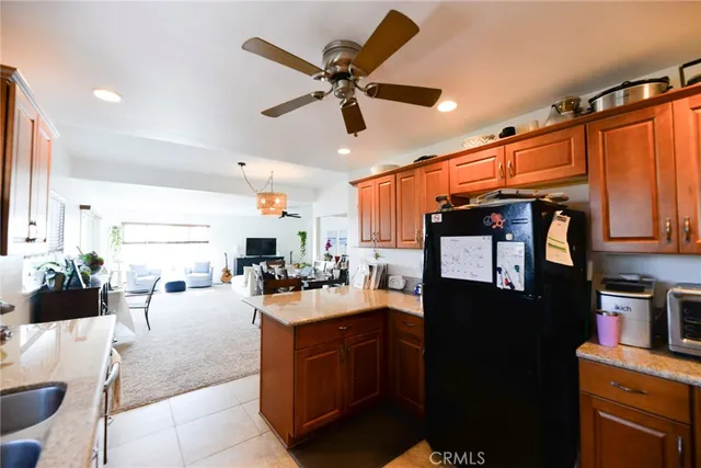 a kitchen with stainless steel appliances kitchen island granite countertop a table chairs and a refrigerator