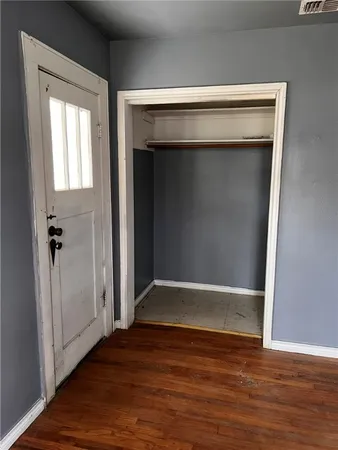 an empty room with wooden floor and closet