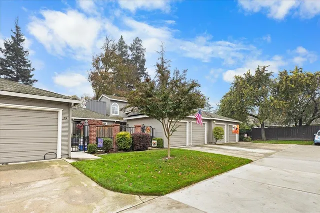a front view of a house with a garden and trees