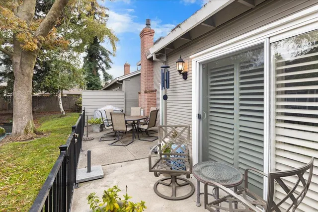 a view of a patio with table and chairs and wooden fence