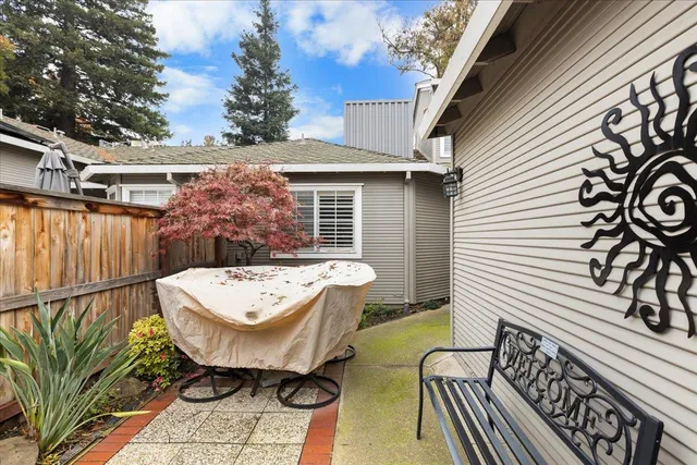 a front view of a house with garden and trees