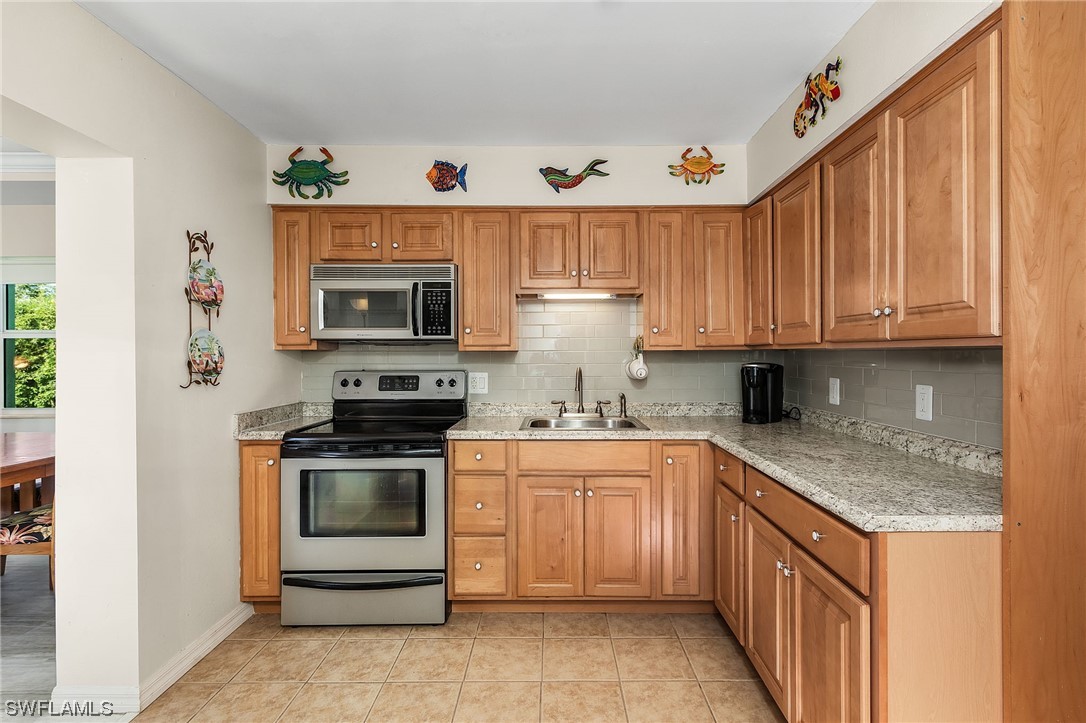 5791 Mackerel Road Bokeelia, FL 33922 - Photo 13 of 24 a kitchen with a sink stove and microwave
