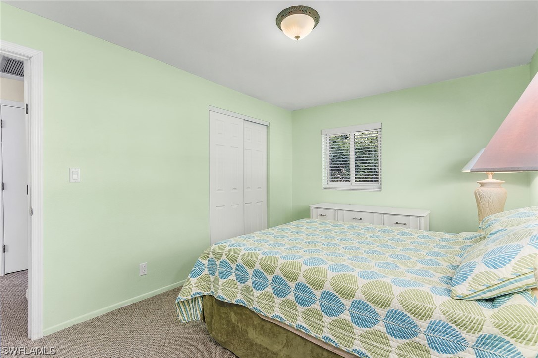 5791 Mackerel Road Bokeelia, FL 33922 - Photo 9 of 24 a bedroom with a bed and a lamp