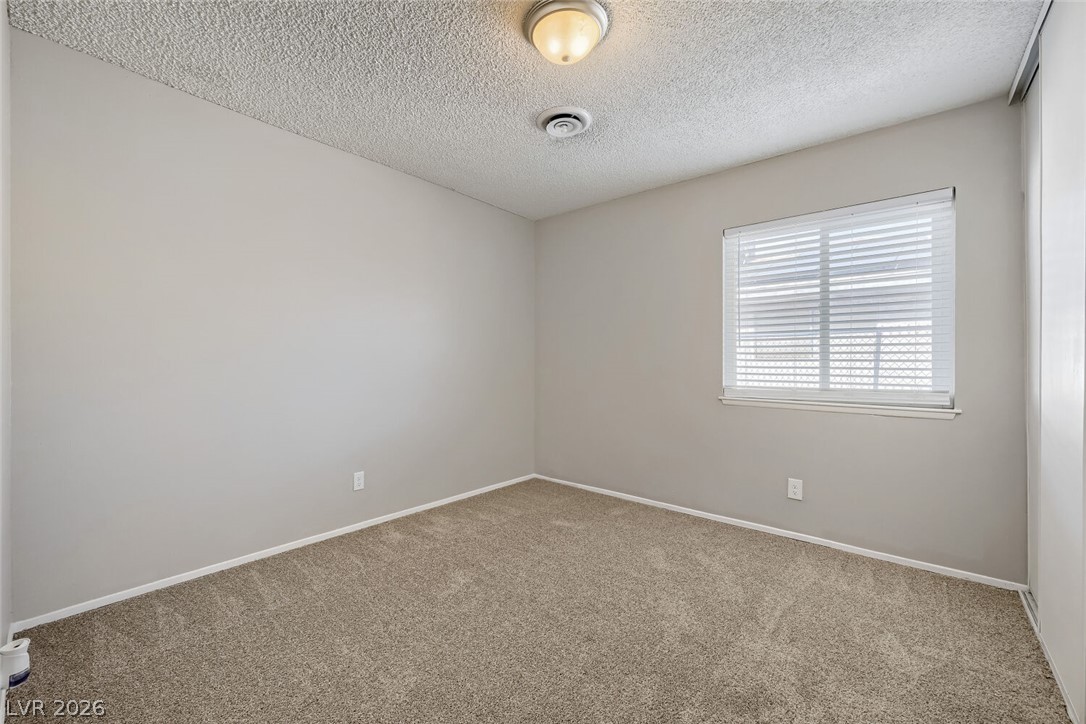 6321 Portola Road Las Vegas, NV 89108 - Photo 15 of 29 A well-lit room awaits personalization, featuring comfortable carpeting and a bright window.