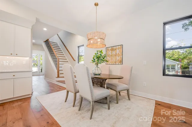 a dining room with wooden floor a chandelier a wooden table and chairs