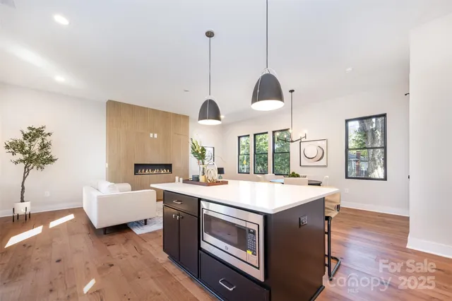 a open kitchen with a sink a window and chairs