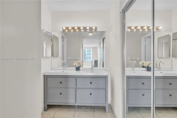 a bathroom with a double vanity sink mirror and bathtub