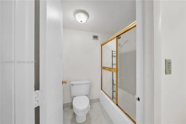 a bathroom with a granite countertop toilet and a sink