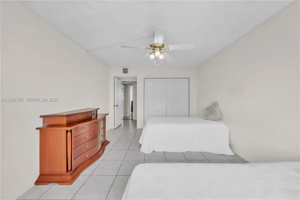 a spacious bedroom with a bed and a chandelier