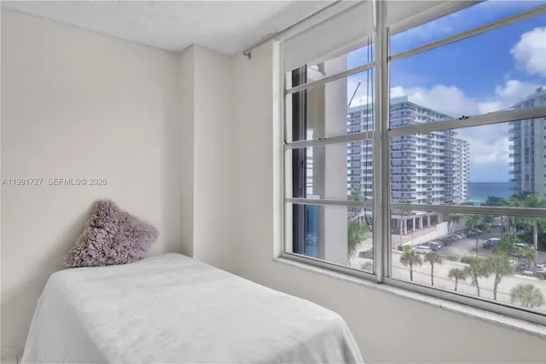 a bedroom with a large window and a bed