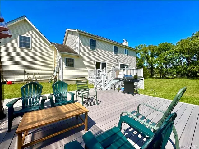 a view of a patio with table and chairs with wooden floor and fence