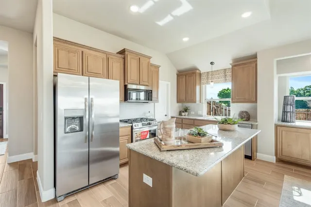 a kitchen with granite countertop a sink stove and refrigerator
