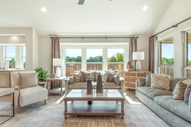a living room with furniture and large windows