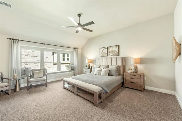 a spacious bedroom with a bed a couch and a window