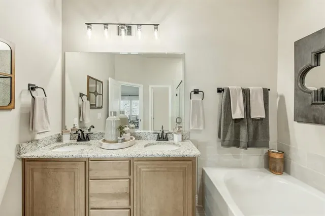 a bathroom with double vanity sink and a mirror