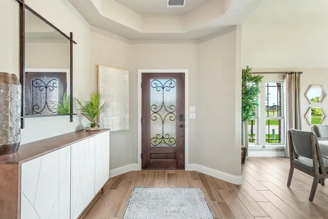 a hallway with wooden floor and a potted plant